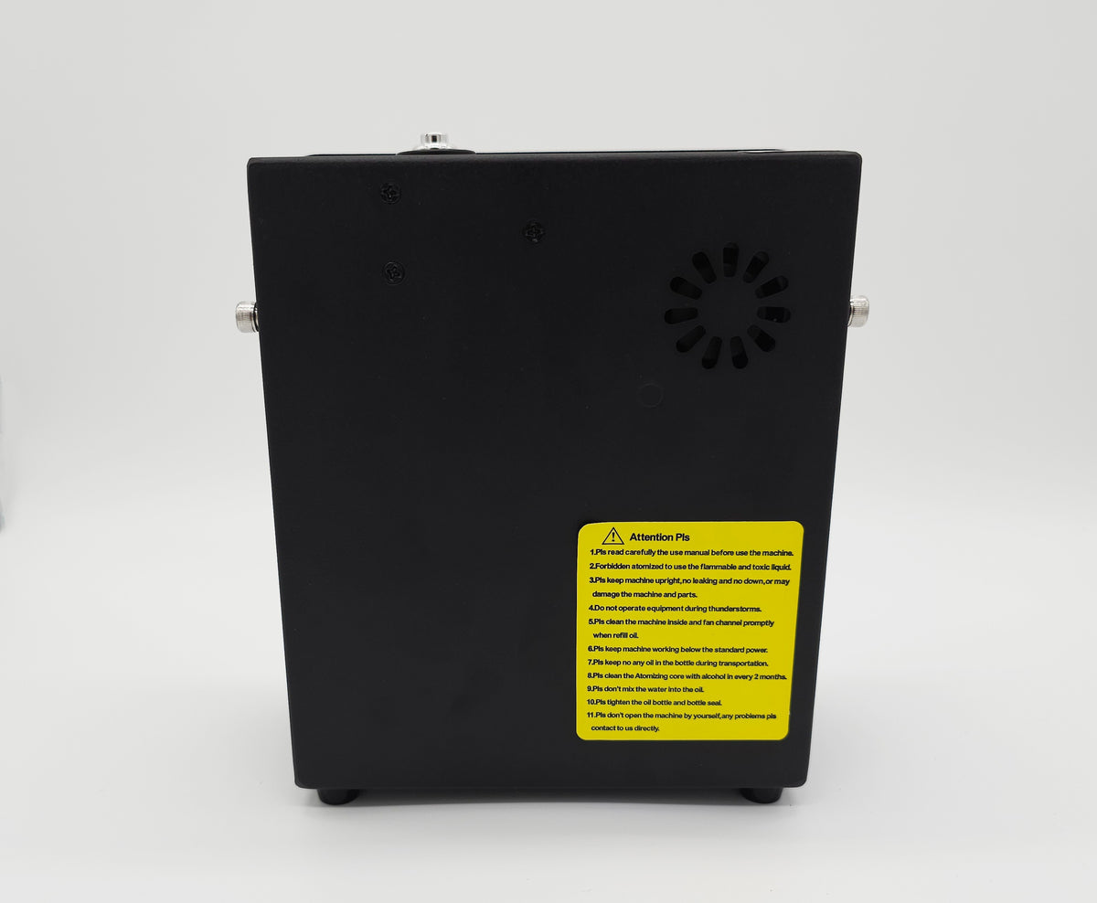 QOption Essence QX300 black cold-air scent diffuser machine with yellow safety instruction label on the back